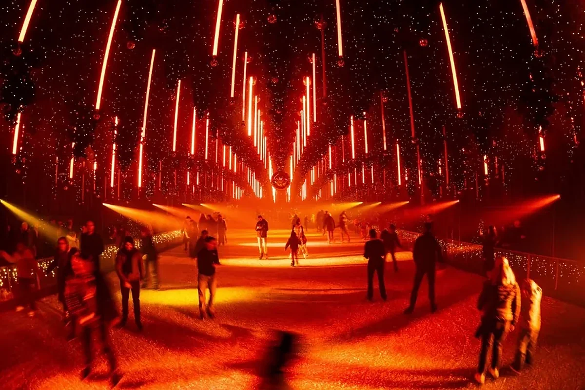 Crowd on an ice rink under hanging Christmas trees faded to red