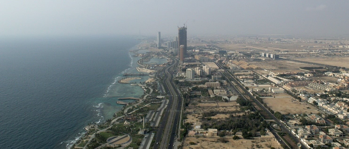 A view down on a beach and a large portion of the Jeddah city from skyscraper